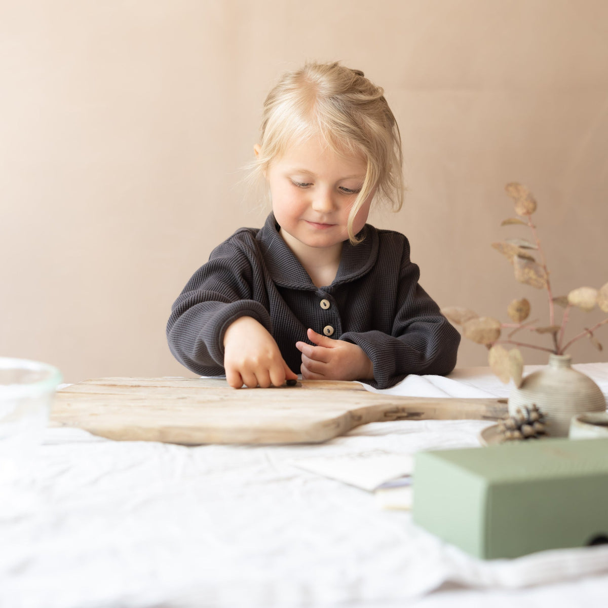 A child presses a hand into impression wax at a table